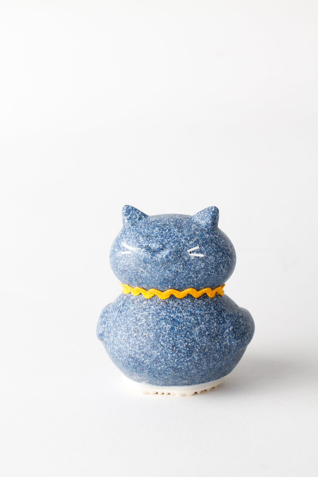 Blue ceramic cat-shaped container with a yellow collar on a white background