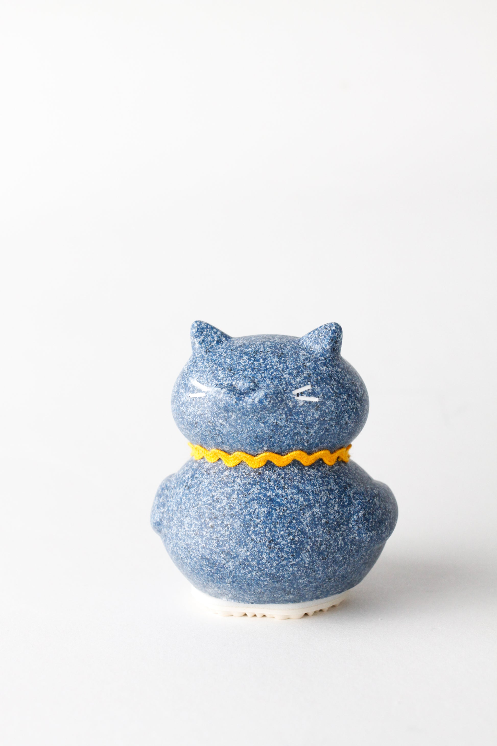 Blue ceramic cat-shaped container with a yellow collar on a white background